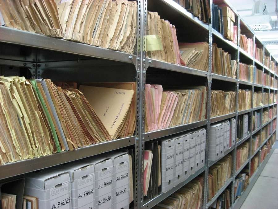Rayonnages d'archives remplis de dossiers papier classés